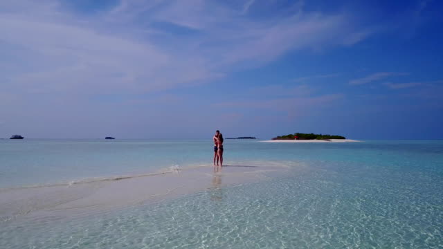 v03962-fliegenden-Drohne-Luftaufnahme-der-Malediven-weißen-Sandstrand-2-Personen-junges-Paar-Mann-Frau-romantische-Liebe-auf-sonnigen-tropischen-Inselparadies-mit-Aqua-blau-Himmel-Meer-Wasser-Ozean-4k