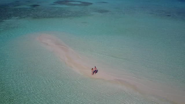 v03870-fliegenden-Drohne-Luftaufnahme-der-Malediven-weißen-Sandstrand-2-Personen-junges-Paar-Mann-Frau-romantische-Liebe-auf-sonnigen-tropischen-Inselparadies-mit-Aqua-blau-Himmel-Meer-Wasser-Ozean-4k