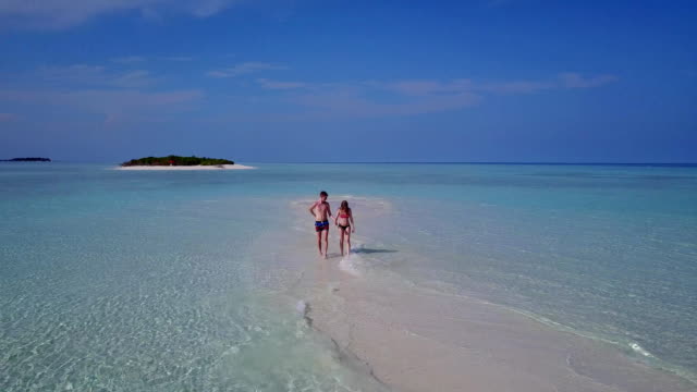 v03901-fliegenden-Drohne-Luftaufnahme-der-Malediven-weißen-Sandstrand-2-Personen-junges-Paar-Mann-Frau-romantische-Liebe-auf-sonnigen-tropischen-Inselparadies-mit-Aqua-blau-Himmel-Meer-Wasser-Ozean-4k