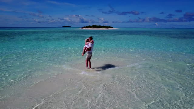 v03916-fliegenden-Drohne-Luftaufnahme-der-Malediven-weißen-Sandstrand-2-Personen-junges-Paar-Mann-Frau-romantische-Liebe-auf-sonnigen-tropischen-Inselparadies-mit-Aqua-blau-Himmel-Meer-Wasser-Ozean-4k