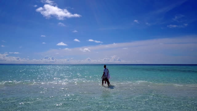 v03946-fliegenden-Drohne-Luftaufnahme-der-Malediven-weißen-Sandstrand-2-Personen-junges-Paar-Mann-Frau-romantische-Liebe-auf-sonnigen-tropischen-Inselparadies-mit-Aqua-blau-Himmel-Meer-Wasser-Ozean-4k