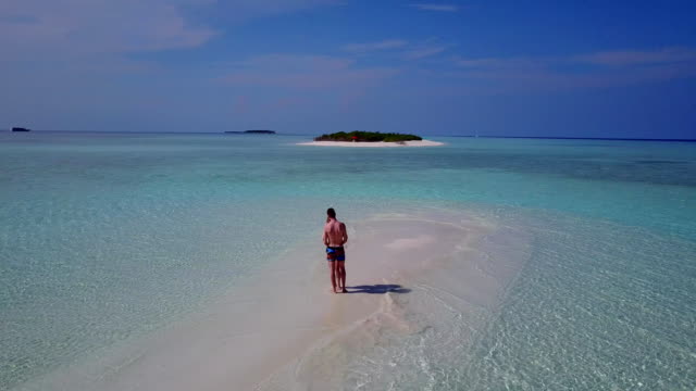 v03956-fliegenden-Drohne-Luftaufnahme-der-Malediven-weißen-Sandstrand-2-Personen-junges-Paar-Mann-Frau-romantische-Liebe-auf-sonnigen-tropischen-Inselparadies-mit-Aqua-blau-Himmel-Meer-Wasser-Ozean-4k