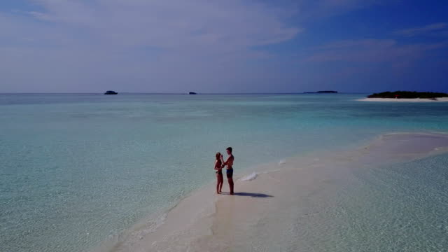 v03881-fliegenden-Drohne-Luftaufnahme-der-Malediven-weißen-Sandstrand-2-Personen-junges-Paar-Mann-Frau-romantische-Liebe-auf-sonnigen-tropischen-Inselparadies-mit-Aqua-blau-Himmel-Meer-Wasser-Ozean-4k