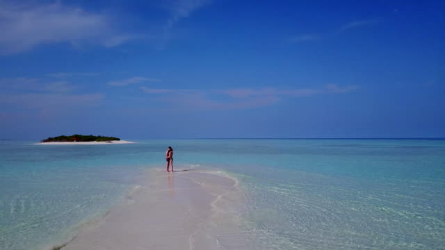 v03965-fliegenden-Drohne-Luftaufnahme-der-Malediven-weißen-Sandstrand-2-Personen-junges-Paar-Mann-Frau-romantische-Liebe-auf-sonnigen-tropischen-Inselparadies-mit-Aqua-blau-Himmel-Meer-Wasser-Ozean-4k
