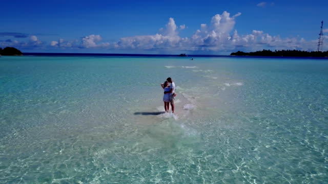 v03931-fliegenden-Drohne-Luftaufnahme-der-Malediven-weißen-Sandstrand-2-Personen-junges-Paar-Mann-Frau-romantische-Liebe-auf-sonnigen-tropischen-Inselparadies-mit-Aqua-blau-Himmel-Meer-Wasser-Ozean-4k