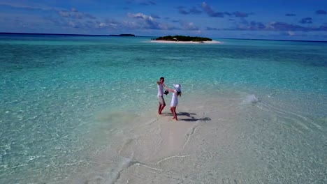 v03908-fliegenden-Drohne-Luftaufnahme-der-Malediven-weißen-Sandstrand-2-Personen-junges-Paar-Mann-Frau-romantische-Liebe-auf-sonnigen-tropischen-Inselparadies-mit-Aqua-blau-Himmel-Meer-Wasser-Ozean-4k