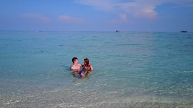v03968-fliegenden-Drohne-Luftaufnahme-der-Malediven-weißen-Sandstrand-2-Personen-junges-Paar-Mann-Frau-romantische-Liebe-auf-sonnigen-tropischen-Inselparadies-mit-Aqua-blau-Himmel-Meer-Wasser-Ozean-4k