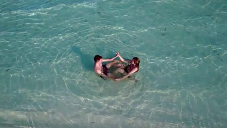 v03988-fliegenden-Drohne-Luftaufnahme-der-Malediven-weißen-Sandstrand-2-Personen-junges-Paar-Mann-Frau-romantische-Liebe-auf-sonnigen-tropischen-Inselparadies-mit-Aqua-blau-Himmel-Meer-Wasser-Ozean-4k