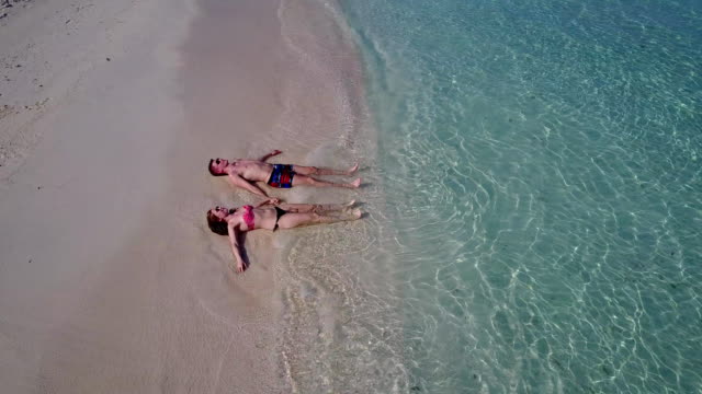 v03975-fliegenden-Drohne-Luftaufnahme-der-Malediven-weißen-Sandstrand-2-Personen-junges-Paar-Mann-Frau-romantische-Liebe-auf-sonnigen-tropischen-Inselparadies-mit-Aqua-blau-Himmel-Meer-Wasser-Ozean-4k