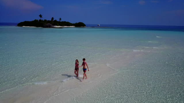 v03894-fliegenden-Drohne-Luftaufnahme-der-Malediven-weißen-Sandstrand-2-Personen-junges-Paar-Mann-Frau-romantische-Liebe-auf-sonnigen-tropischen-Inselparadies-mit-Aqua-blau-Himmel-Meer-Wasser-Ozean-4k