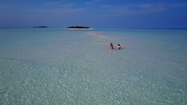 v04007-fliegenden-Drohne-Luftaufnahme-der-Malediven-weißen-Sandstrand-2-Personen-junges-Paar-Mann-Frau-romantische-Liebe-auf-sonnigen-tropischen-Inselparadies-mit-Aqua-blau-Himmel-Meer-Wasser-Ozean-4k