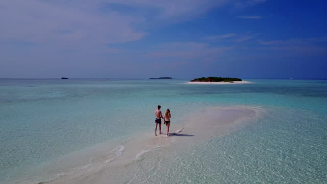 v04014-fliegenden-Drohne-Luftaufnahme-der-Malediven-weißen-Sandstrand-2-Personen-junges-Paar-Mann-Frau-romantische-Liebe-auf-sonnigen-tropischen-Inselparadies-mit-Aqua-blau-Himmel-Meer-Wasser-Ozean-4k