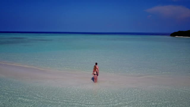 v04030-fliegenden-Drohne-Luftaufnahme-der-Malediven-weißen-Sandstrand-2-Personen-junges-Paar-Mann-Frau-romantische-Liebe-auf-sonnigen-tropischen-Inselparadies-mit-Aqua-blau-Himmel-Meer-Wasser-Ozean-4k