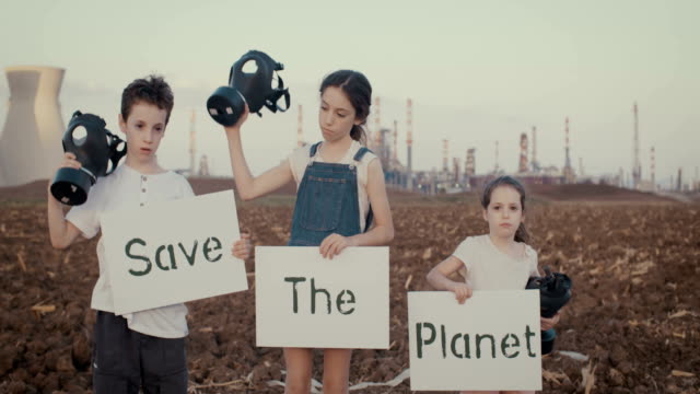 Salvar-la-planta.-Niños-pequeños-sosteniendo-carteles-de-pie-cerca-de-una-refinería-con-máscaras-de-gas