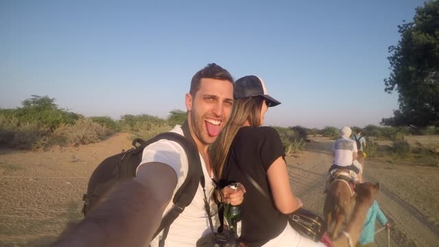 Paar,-wobei-ein-Selbstporträt-in-ein-Kamel-reiten-in-der-Wüste