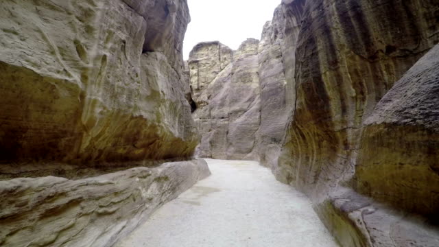 Touristen-zu-Fuß-entlang-des-Canyons-in-Petra.-Blick-auf-die-Stadt-Petra-in-Jordanien.-Touristische-Route-von-Petra-in-Jordanien.-Geschnitzte-Stadt-in-den-Bergen.