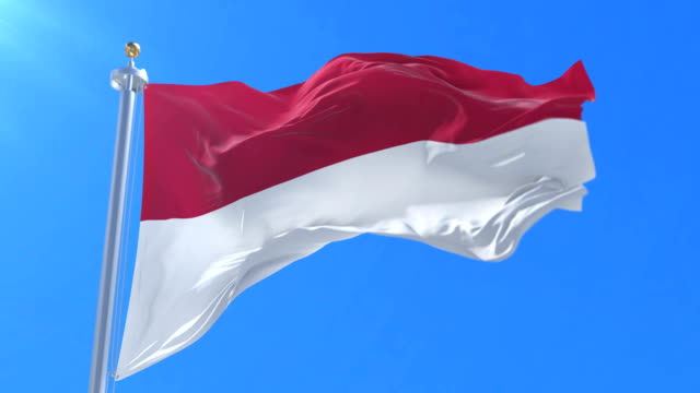 Bandera-de-Indonesia-ondeando-al-viento-en-lento-en-cielo-azul,-lazo
