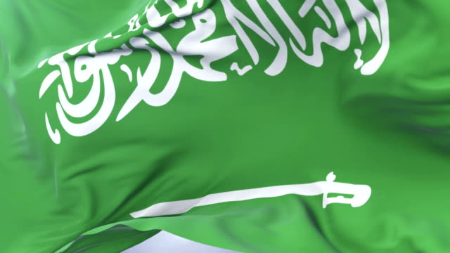 Saudi-Arabia-flag-waving-at-wind-in-slow-with-blue-sky,-loop