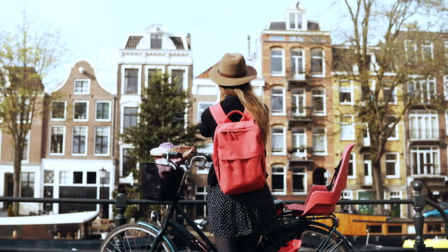 Chica-con-bicicleta-enviando-video-a-amigos-en-línea.-Blogs-de-mujer-bastante-Europea-en-las-redes-sociales.-Vista-posterior.-4K