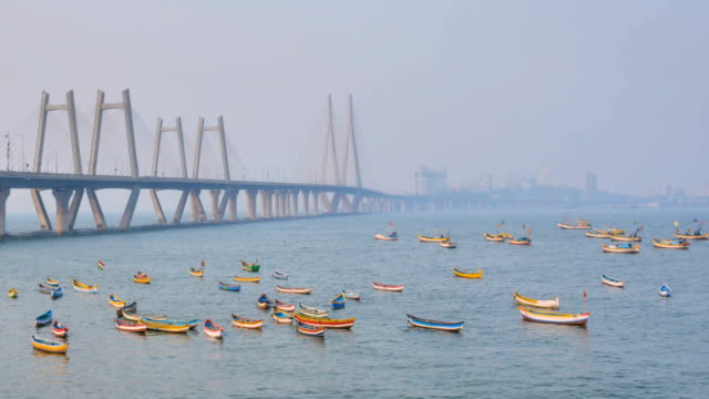 Timelapse-shot-of-Colorful-fishing-boats-are-parked-under-the-modern-bridge