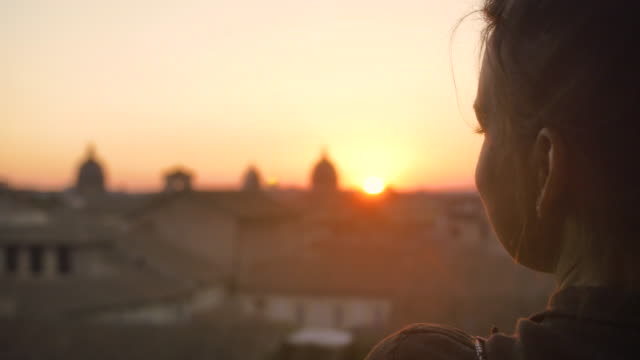 Schöne-junge-Frau-zu-Fuß-in-Richtung-hohen-Balkon-auf-der-Campidoglio,-Stadtbild-von-Rom-bei-Sonnenuntergang-betrachten-historische-Gebäude-und-Kuppeln-Zeitlupe-Steadycam-zu-sehen