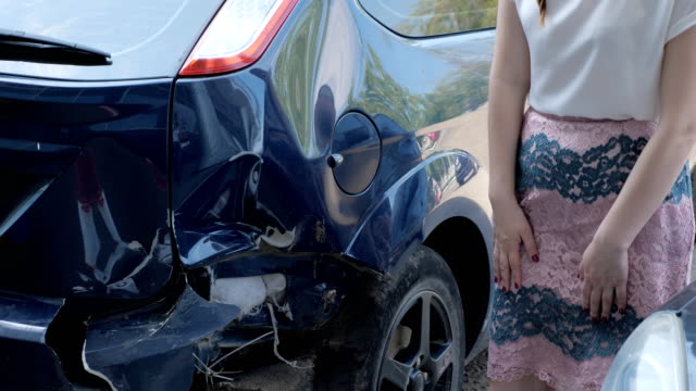 frustrated-brunette-woman-is-standing-near-a-broken-car