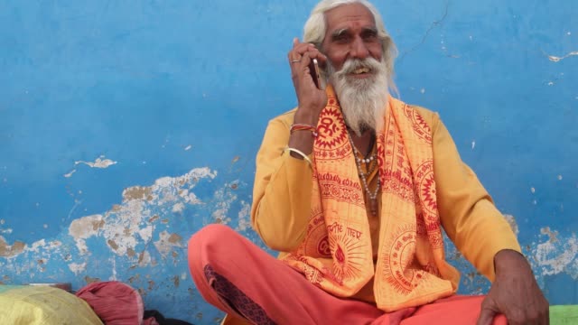 Breite-Schuss-von-einem-indischen-weisen-auf-seinem-Handy-Einzug-in-Pushkar,-Rajasthan