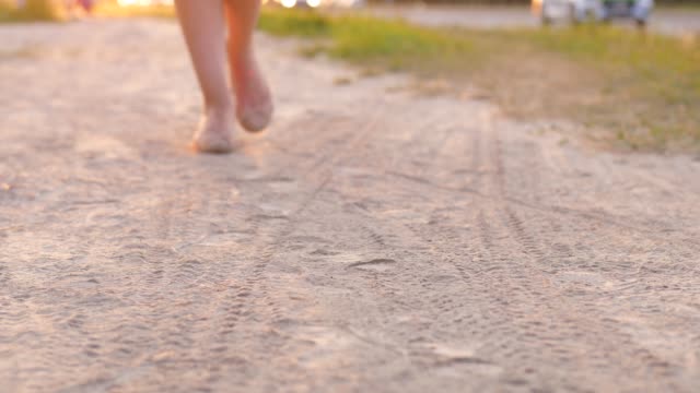Woman-feet-in-flat-shoes-walk-on-dusty-road