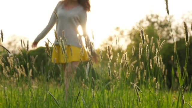 Woman-walk-on-green-field-in-deep-grass