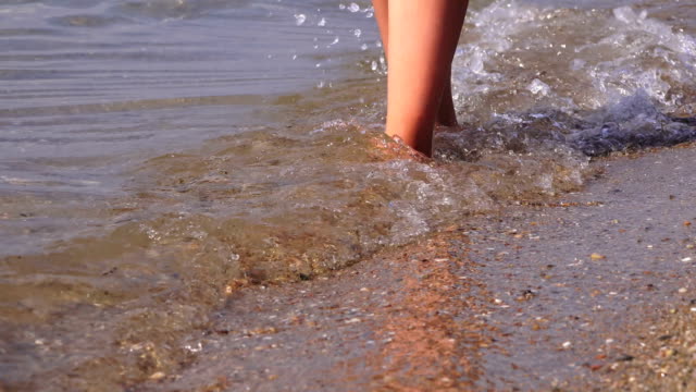 Beautiful-female-feet-walking-along-the-sea