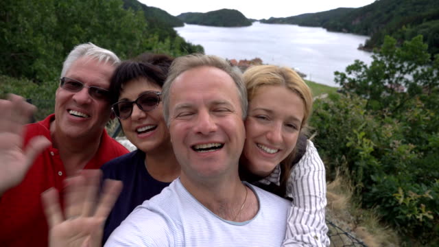 Eine-große,-glückliche-Familie-nimmt-ein-Selfie-oder-nutzt-Telefon-anrufen-Videokamera-an-der-Küste.