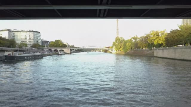 Drone-footage-passing-under-the-bridge-and-going-up-to-show-Seine-River-and-Eiffel-Tower-in-Paris