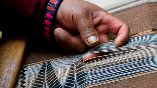 Close-up-of-a-man-hands-weaving-on-a-loom-as-his-ancestors-used-to-do