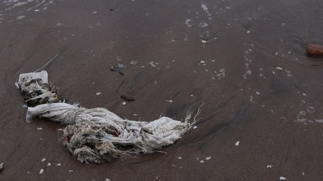 Tropischer-Meeresstrand-stark-verschmutzt-mit-Müll-und-Plastiktüten-in-allen-Varianten