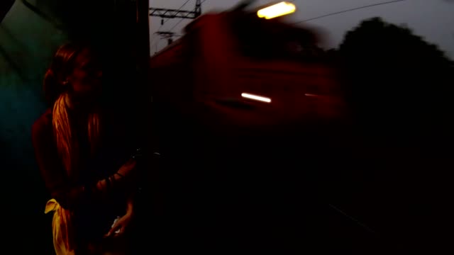woman-near-open-doors-in-moving-train-railway-of-Kolkata-evening