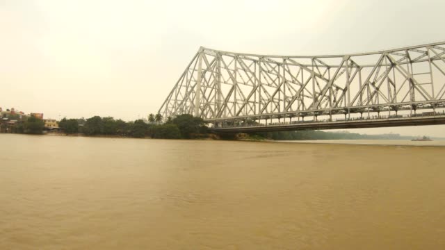 Howrah-Bridge-Blick-von-schwimmenden-Boot-im-Bau-Gebäude-der-Stadt-Kalkutta-am-Ufer