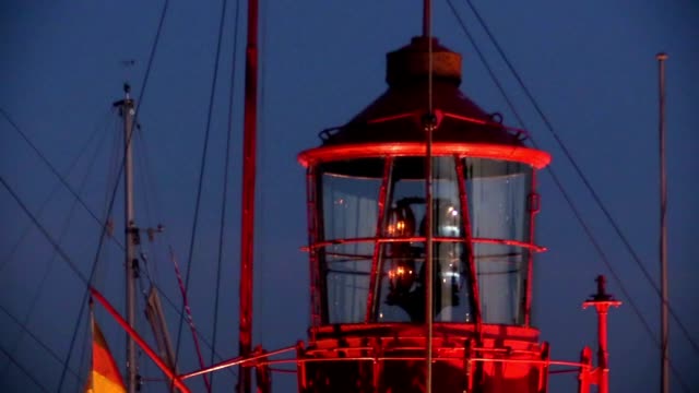 Rotating-lighthouse-at-dusk-in-harbor