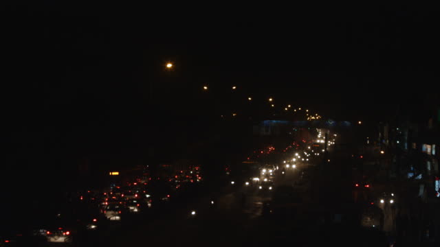 Time-lapse-shot-of-traffic-on-road-in-a-city-at-night,-Delhi,-India