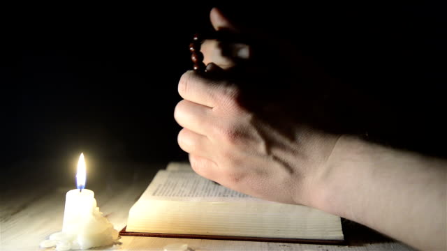 Beten-Hände-über-eine-Gebetsbuch