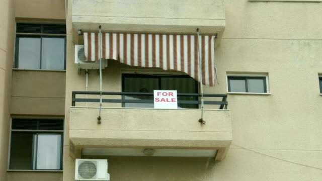 For-sale-sign-on-apartment-balcony.-Real-estate-agency-services.