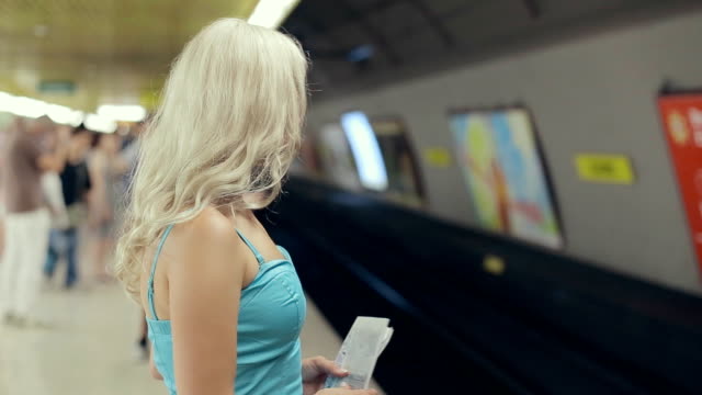 Süße-blonde-mit-einer-Karte-in-Ihre-Hände-warten-auf-die-U-Bahn-Auto