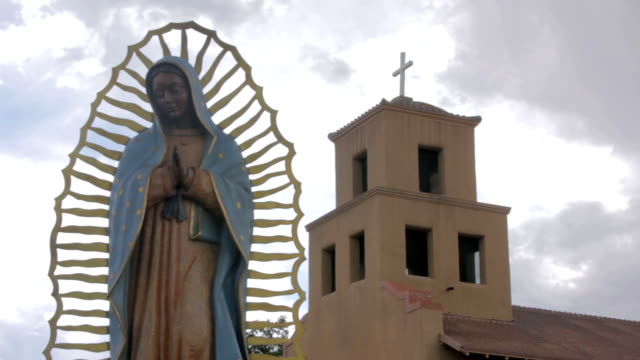 Una-estatua-de-la-Virgen-Guadalupe-frente-a-una-iglesia-católica-mexicana