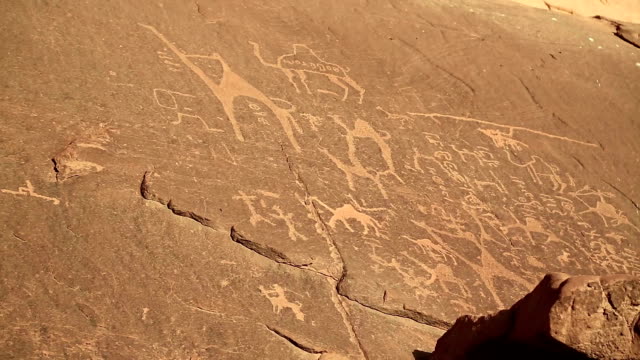 Alten-Felszeichnungen,-die-Darstellung-von-Menschen-und-Kamelen-in-der-Wüste-Wadi-Rum,-Jordanien
