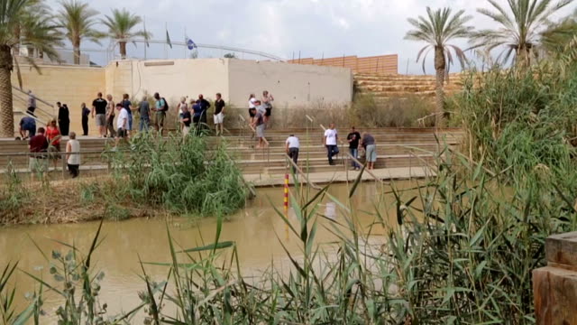 Tourists-near-the-Sacred-water-of-the-River-Jordan.-River-where-Jesus-of-Nazareth-was-baptized-by-John-the-Baptist.-The-border-between-Jordan-and-Israel.