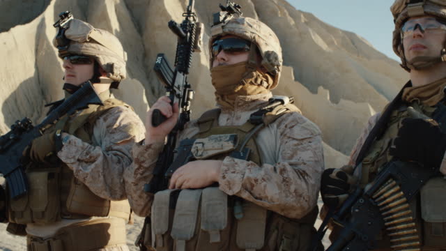 Kader-der-vollausgerüsteten-Soldaten,-die-in-einer-Linie-in-der-Wüste-stehen.