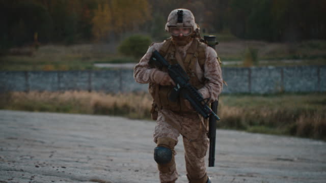 Retrato-de-soldado-totalmente-equipado-y-armado-corriendo-al-aire-libre.-Cámara-lenta.