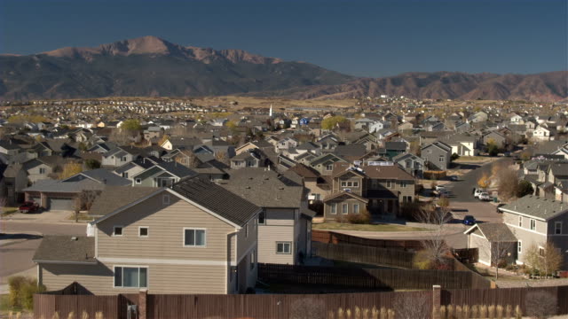 AERIAL-Luxury-row-houses-in-suburban-town-with-Rocky-Mountains-in-the-background