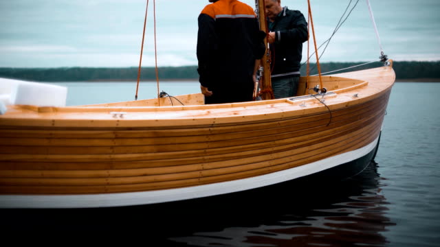 Master-und-sein-Assistent-arbeiten-auf-Holz-Segelboot