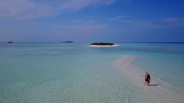 v03884-fliegenden-Drohne-Luftaufnahme-der-Malediven-weißen-Sandstrand-2-Personen-junges-Paar-Mann-Frau-romantische-Liebe-auf-sonnigen-tropischen-Inselparadies-mit-Aqua-blau-Himmel-Meer-Wasser-Ozean-4k