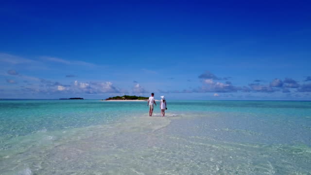 v03942-fliegenden-Drohne-Luftaufnahme-der-Malediven-weißen-Sandstrand-2-Personen-junges-Paar-Mann-Frau-romantische-Liebe-auf-sonnigen-tropischen-Inselparadies-mit-Aqua-blau-Himmel-Meer-Wasser-Ozean-4k